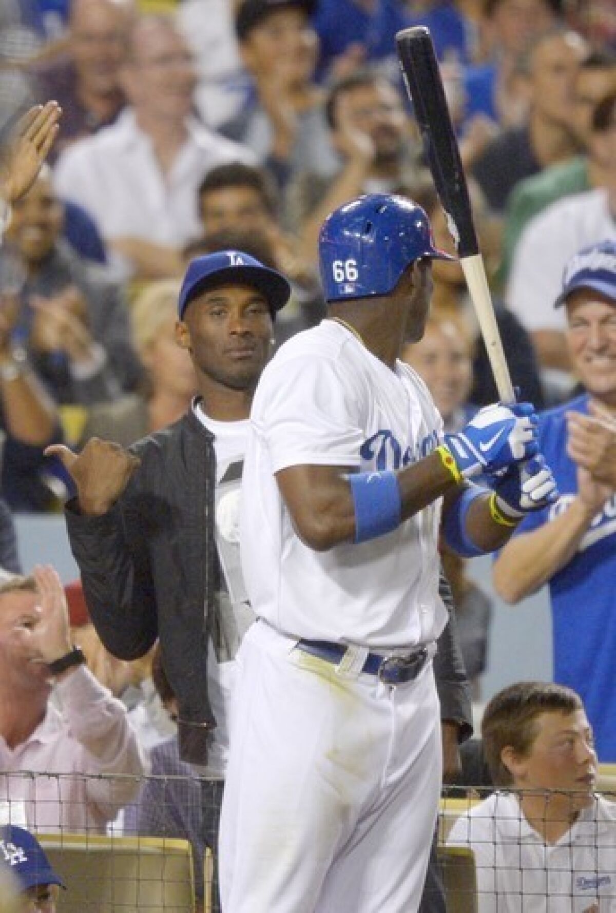 Kobe Bryant, left, gestures as Yasiel Puig looks on during the fourth inning of the Dodgers' matchup with the New York Yankees at Dodger Stadium on Wednesday.