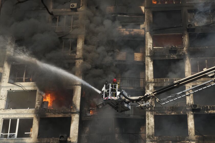 Firefighters work in an apartment building damaged by shelling in Kyiv, Ukraine, Tuesday, March 15, 2022. (AP Photo/Efrem Lukatsky)