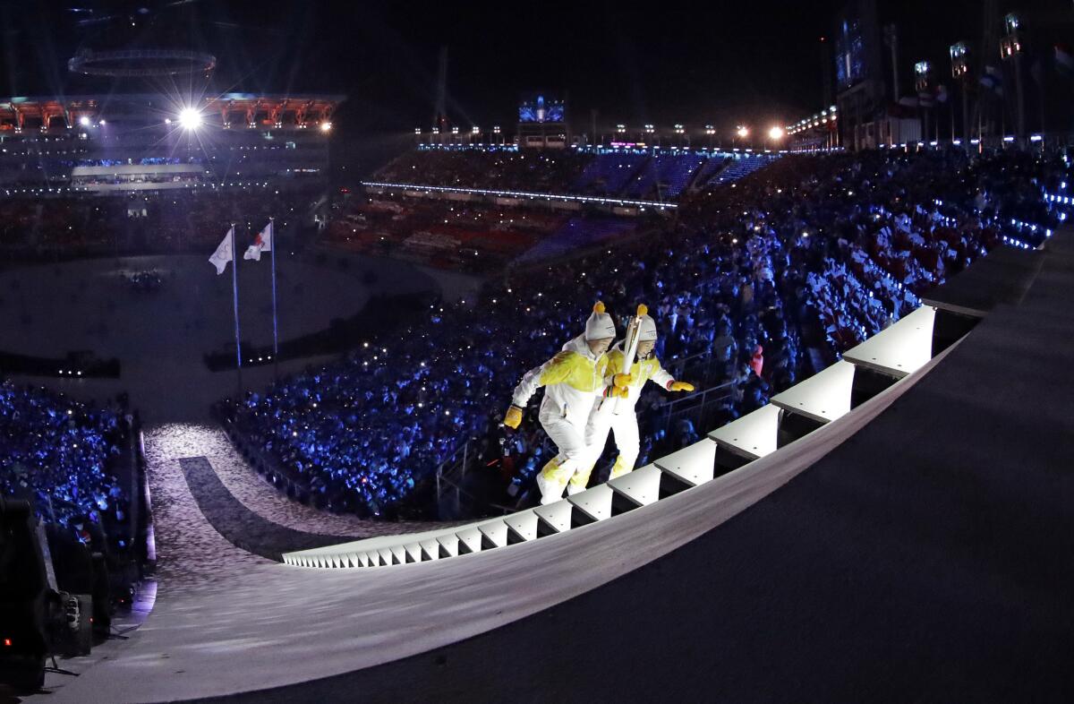 North Korea's Jong Su Hyon, left, and South Korea's Park Jong-ah carry the torch during the opening ceremony of the 2018 Winter Olympics in Pyeongchang, South Korea.