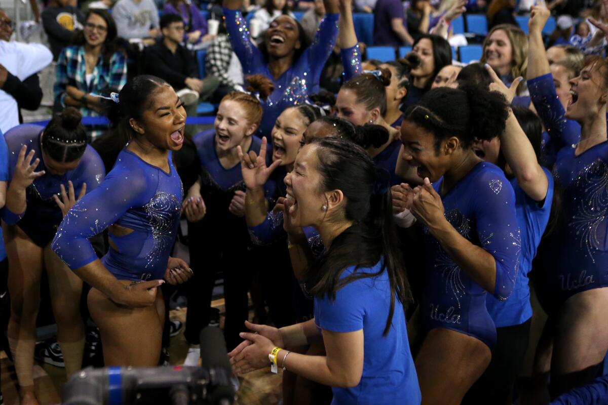The UCLA gymnastics team celebrates April 1, 2023, during the regional final at Pauley Pavilion.
