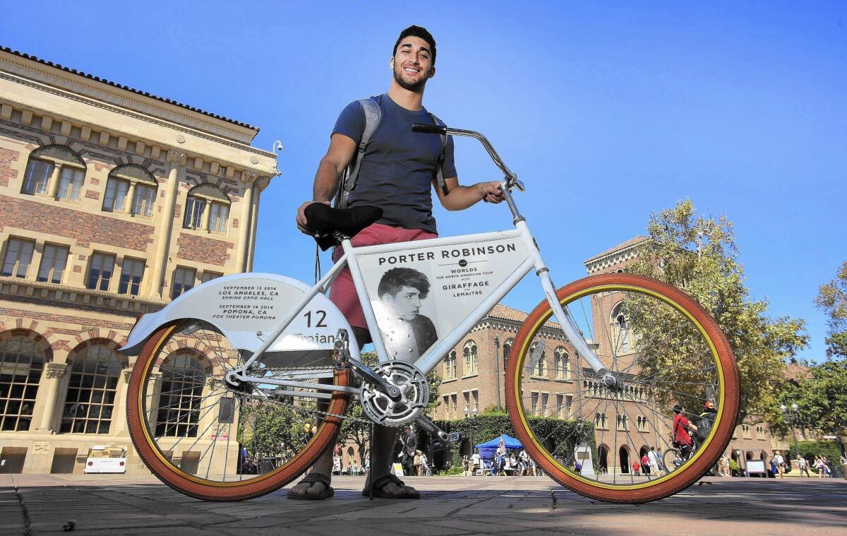 USC junior Eamon Barkhordarian walks a signature white and orange FreeBike on campus. Barkhordarian is one of two FreeBike Project ambassadors at USC and does repairs on about 50 students' bikes.