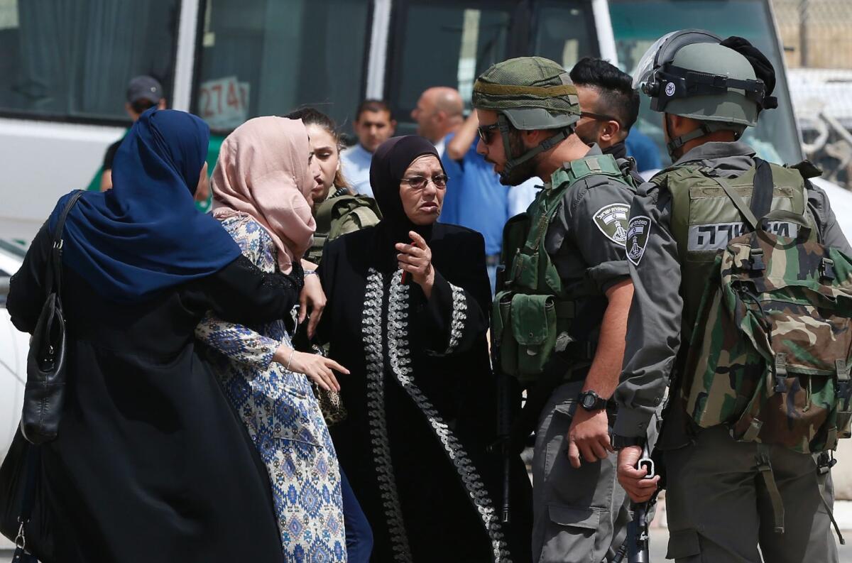 Palestinian women confront Israeli security forces at the Qalandia checkpoint between Jerusalem and the West Bank city of Ramallah on April 27, 2016, after two Palestinians were shot to death after one of them allegedly threw a knife at a policeman.
