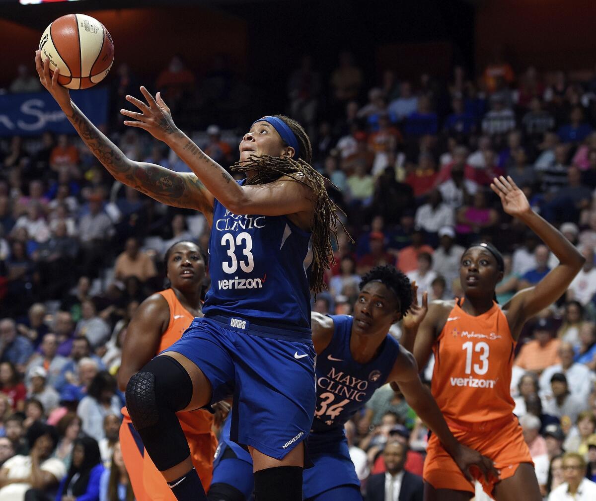 FILE - In this June 9, 2018, file photo, Minnesota Lynx guard Seimone Augustus (33) uses a screen from teammate Sylvia Fowles (34) to get a clear drive to the basket against the Connecticut Sun during the first half of a WNBA basketball game in Uncasville, Conn. Seimone Augustus has retired from playing and will be an assistant coach for the Los Angeles Sparks, the team announced Thursday, May 13, 2021. (Sean D. Elliot/The Day via AP, File)