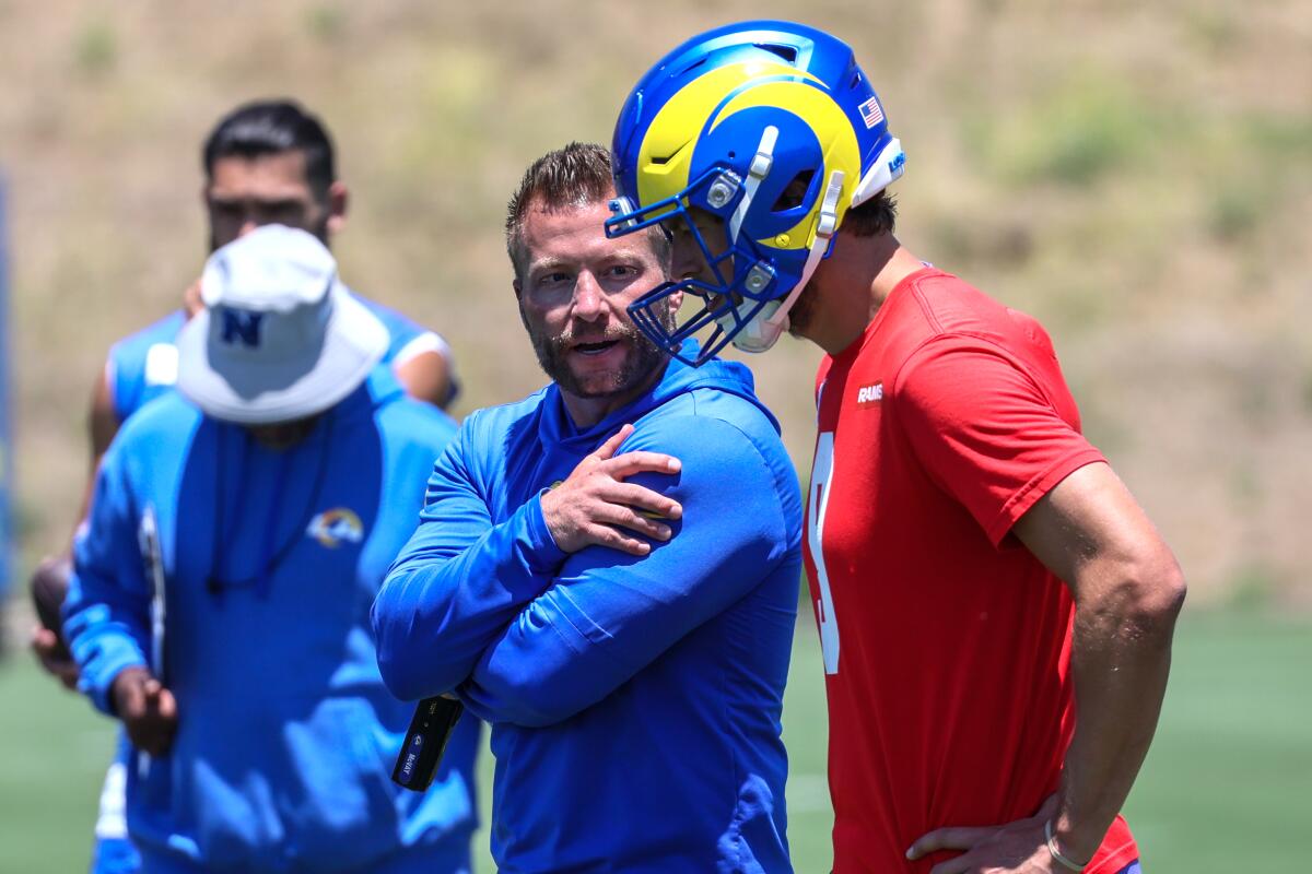 Rams coach Sean McVay talks with quarterback Matthew Stafford on the practice field sideline.