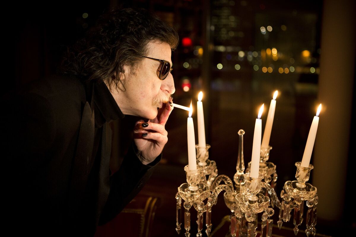 La leyenda del rock argentino Charly Garcia prende un cigarro con una vela antes de una entrevista en Buenos Aires, Argentina en una fotografía de archivo del 14 de agosto de 2013. Garcia ingresó a un hospital para una revisión el 28 de diciembre de 2016 informaron su abogada y su productor.