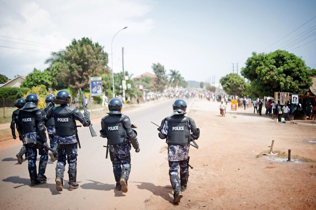 Riot police advance toward a crowd of opposition supporters in the centre of Ggaba, a suburb of Kampala, on Thursday during Uganda's national elections.