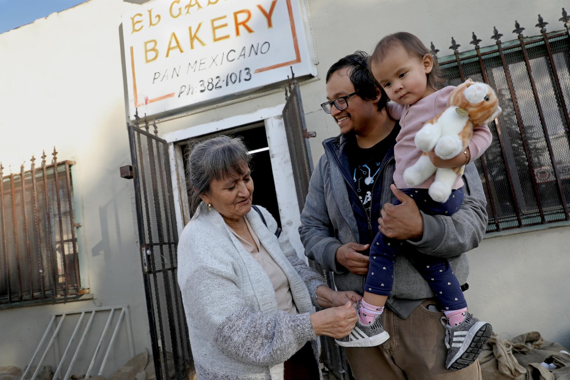 A family outside their family-run business, El Gallito Bakery, which was damaged by a flood in Planada, Calif.