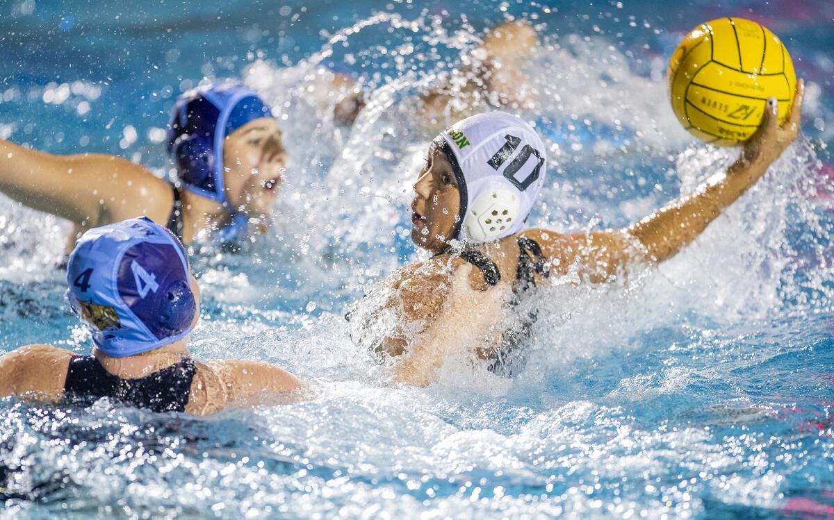 Edison's Sam Worley takes a shot against Marina's Maddison Clobes (4) during a Wave League match at Corona del Mar High on Thursday.