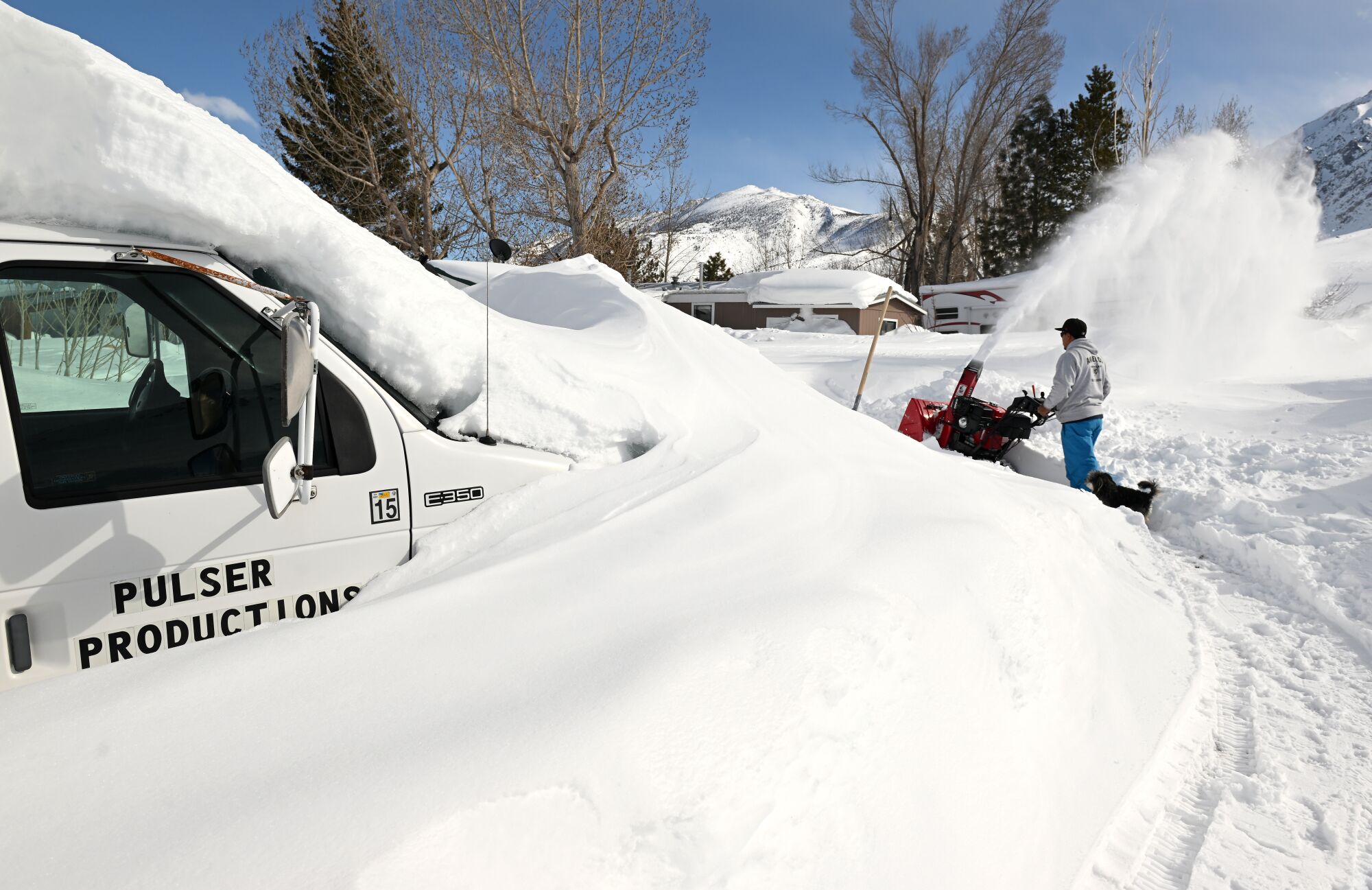 Eliazar Raya blows snow from his walkway along McGee Creek Road south of Mammoth Lakes.