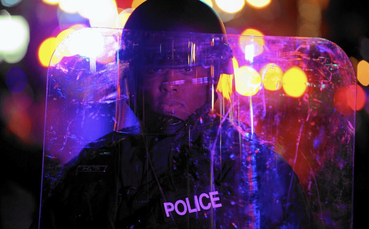 An officer keeps protesters away from the Ferguson, Mo., police station in November after the grand jury decision to not indict the officer who killed Michael Brown.