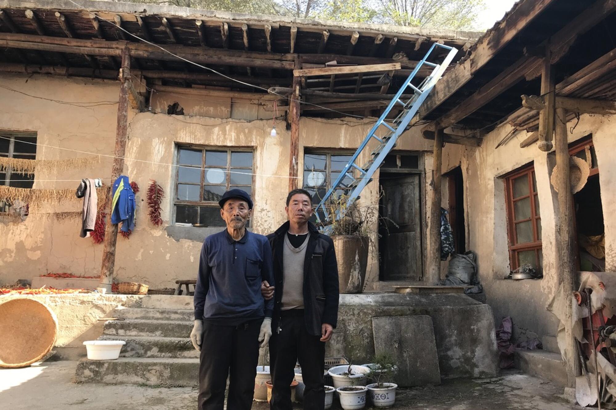 Yang Qinglai and his son Yang Jiacun are among a handful of residents still living in Lianghekou, China