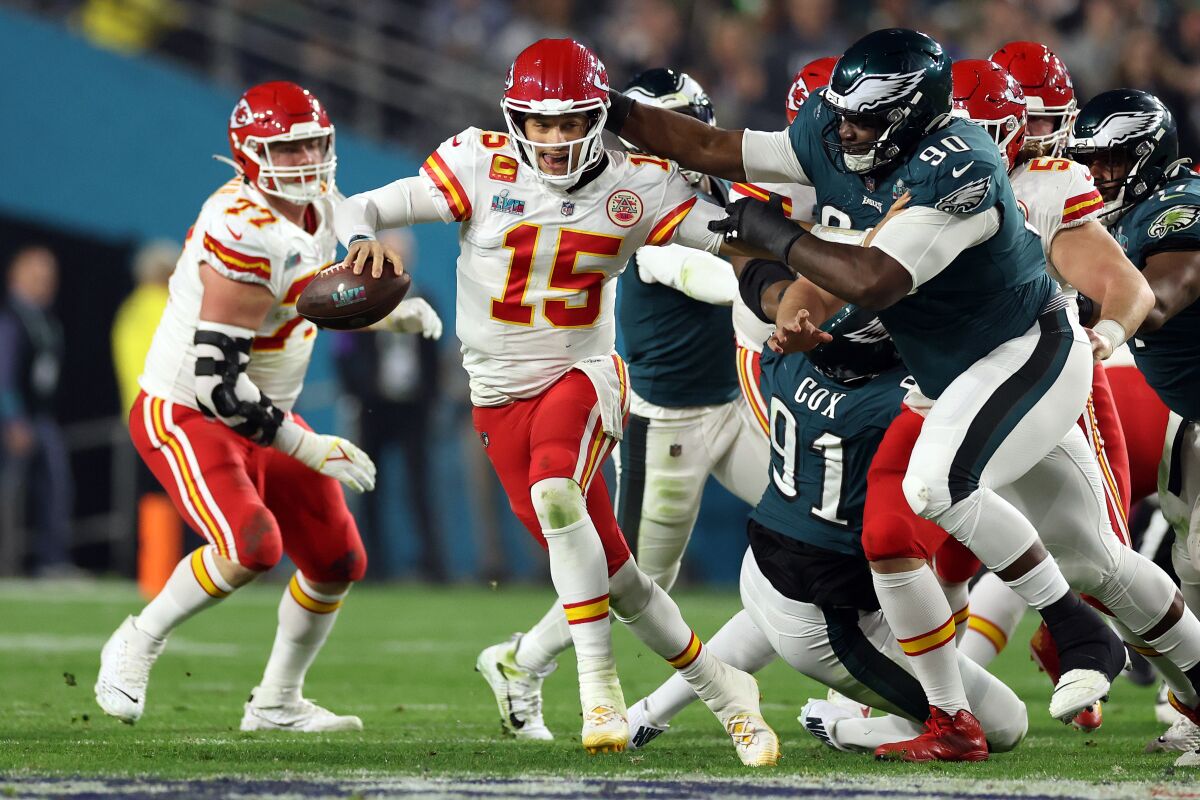 Kansas City Chiefs quarterback Patrick Mahomes scrambles away from Philadelphia Eagle Jordan Davis in Super Bowl LVII.