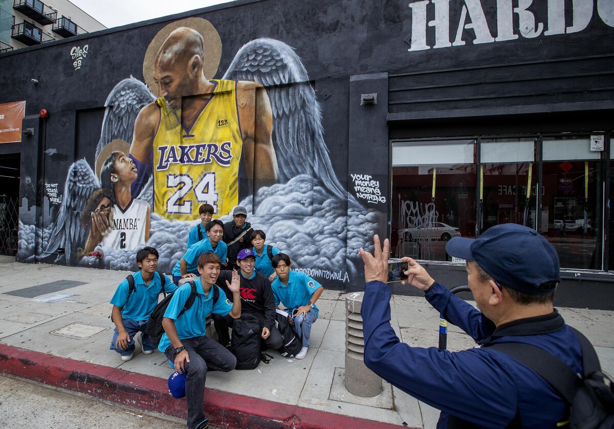 Hideharu Tanaka photographs students in front of a mural of Kobe Bryant and his daughter Gianna