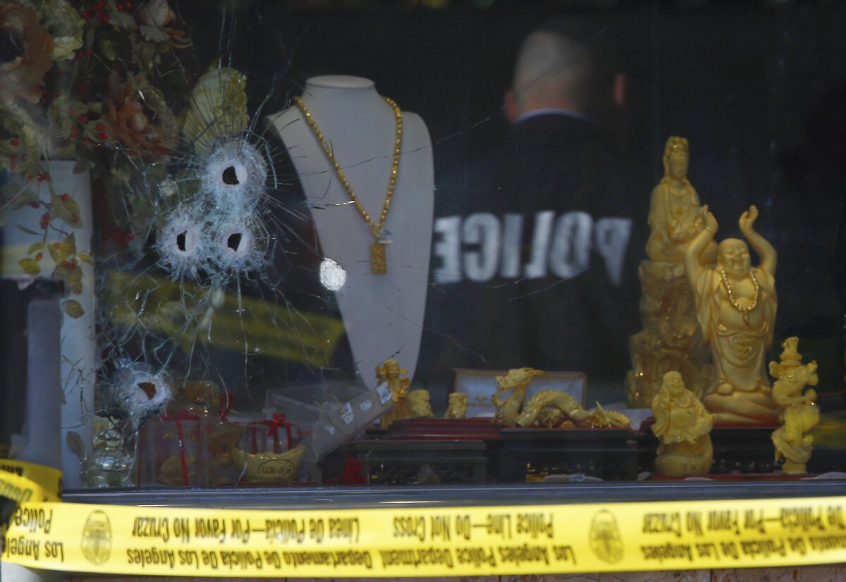 Police investigate the shooting of a security guard at a jewelry store in downtown L.A.'s Chinatown earlier this year. Paramedics treated the man for an arm wound, according to reports from the scene.