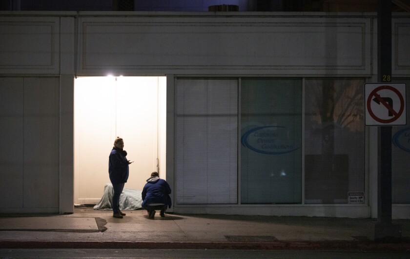 Volunteers talk to a homeless person in downtown San Diego in January 2020.
