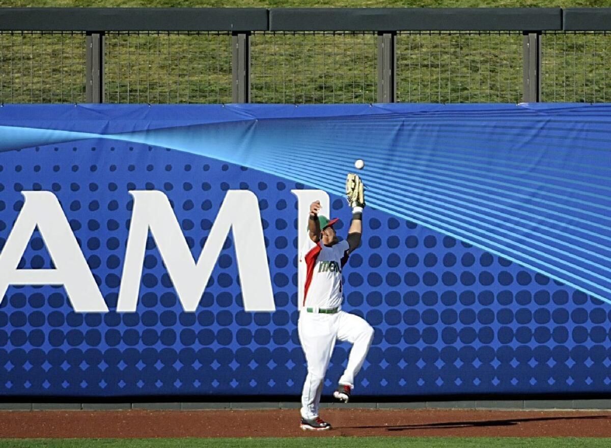 Mexico left fielder Edgar Gonzalez misplays a fly ball in the ninth inning that allowed Italy to score go-ahead run.