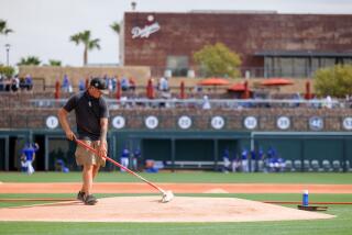 GLENDALE, AZ - MARCH 20: A groundsman prepares the pitchers mound before the MLB Spring Training.