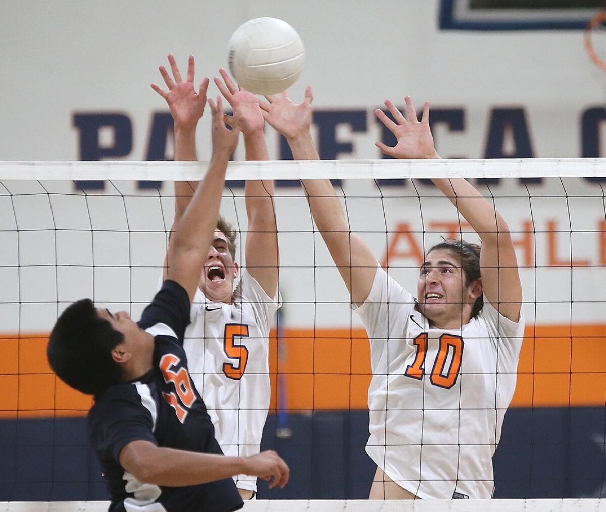 Pacifica Christian Orange County's Caleb Snider (5) and Kyle Barnard (10) put up a block against Samueli Academy outside hitter David Mendiola during a match on May 2, 2018.