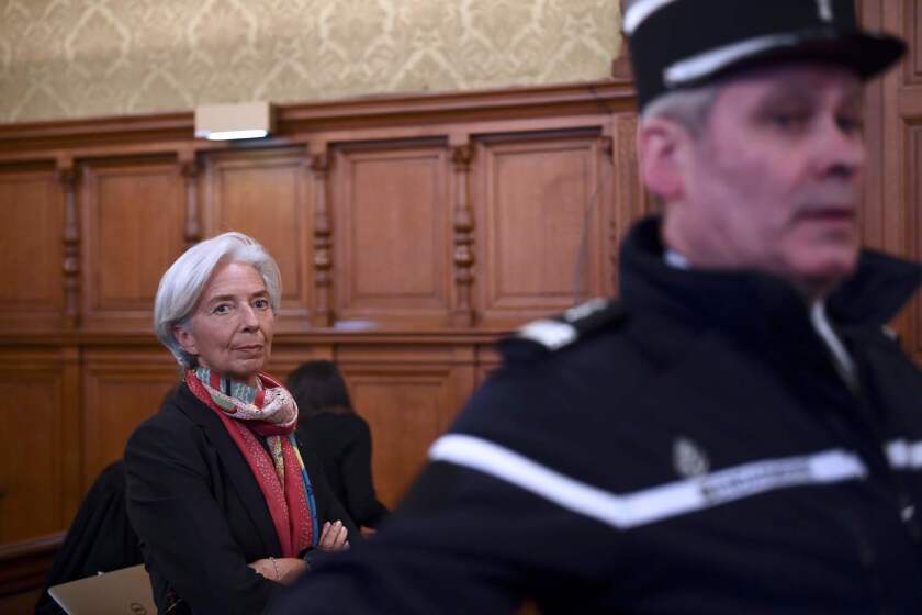 International Monetary Fund chief Christine Lagarde sits near a gendarme before the start of her trial before the Court of Justice of the Republic, a special tribunal used to try ministers, in Paris on Dec. 12.