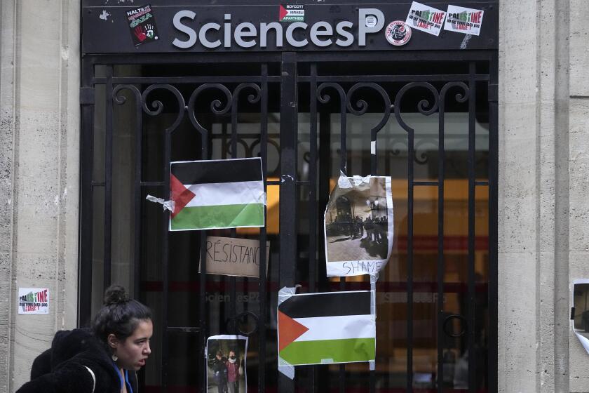 A student walks past th entrance of Sciences-Po university in Paris Friday, April 26, 2024. Students in Paris inspired by Gaza solidarity encampments at campuses in the United States blocked access to a campus building at a prestigious French university Friday, prompting administrators to move all classes online. The pro-Palestinian protest at the Paris Institute of Political Studies, known as Sciences Po, came two days after police broke up a separate demonstration at one of the university's amphitheaters. (AP Photo/Michel Euler)