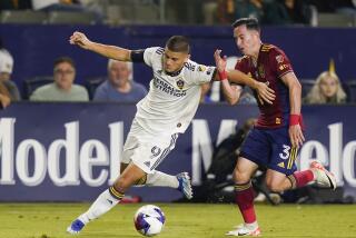 LA Galaxy forward Dejan Joveljic, left, and Real Salt Lake defender Bryan Oviedo vie for the ball.