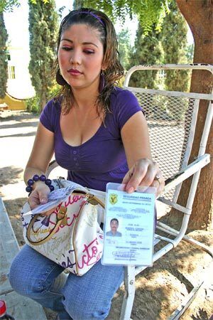 Arely Montoya of Guamuchil, Mexico, holds her brothers ID card from his job as a hospital security guard. Jose Alan Montoya was later recruited to work for drug traffickers and was kiled by army troops.