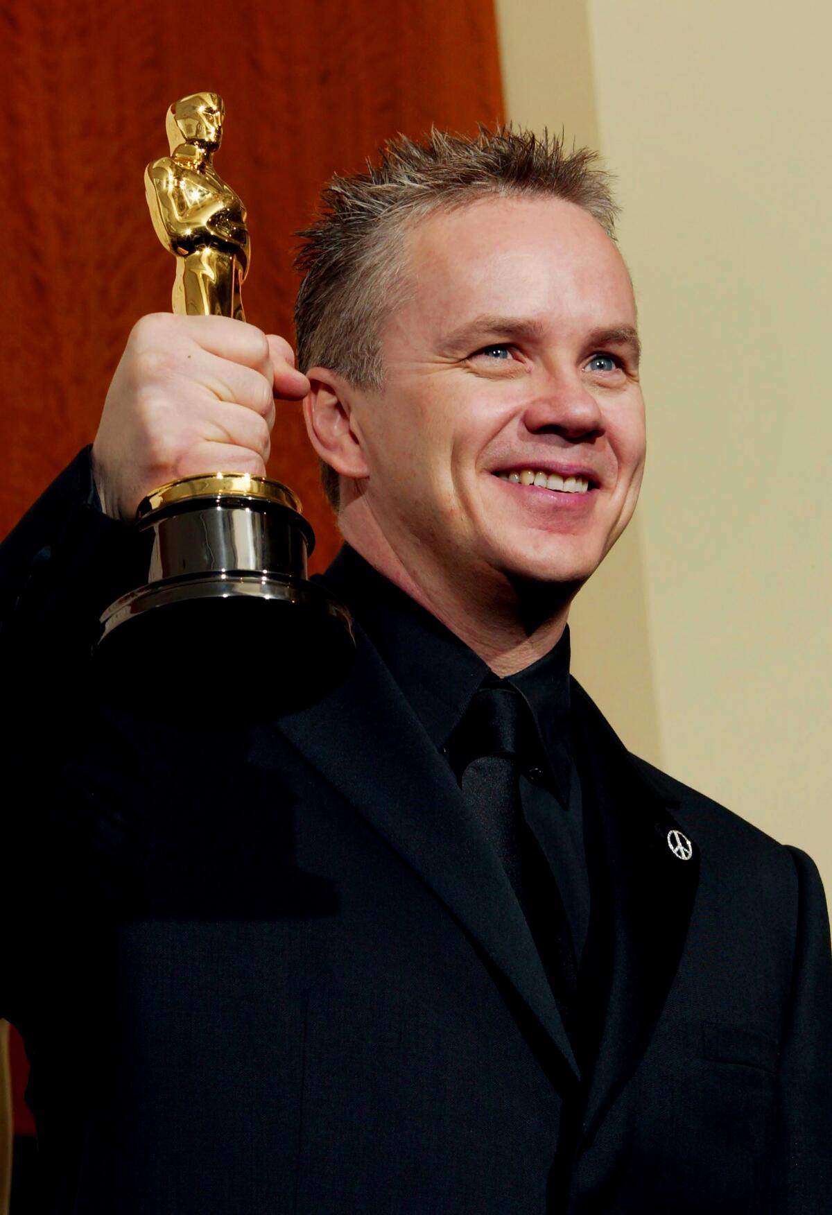Actor Tim Robbins poses with his Oscar for Best Actor In A Supporting Role during ton February 29, 2004
