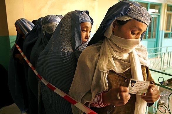 Holding their voter cards, women line up for balloting in Afghanistan, where the Taliban's threats of violence kept many away from the polls.