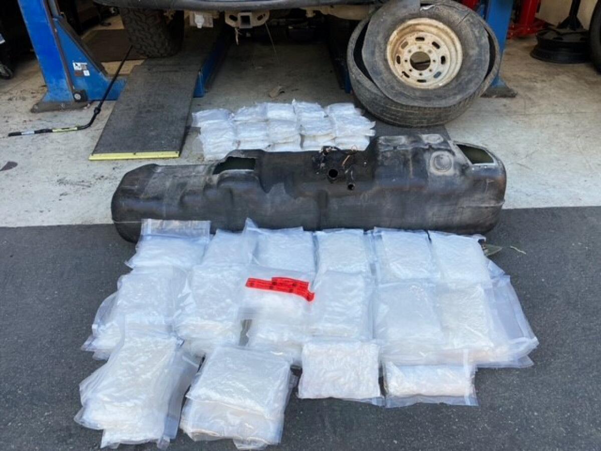 Packages of confiscated drugs are on the ground near a worn tire.