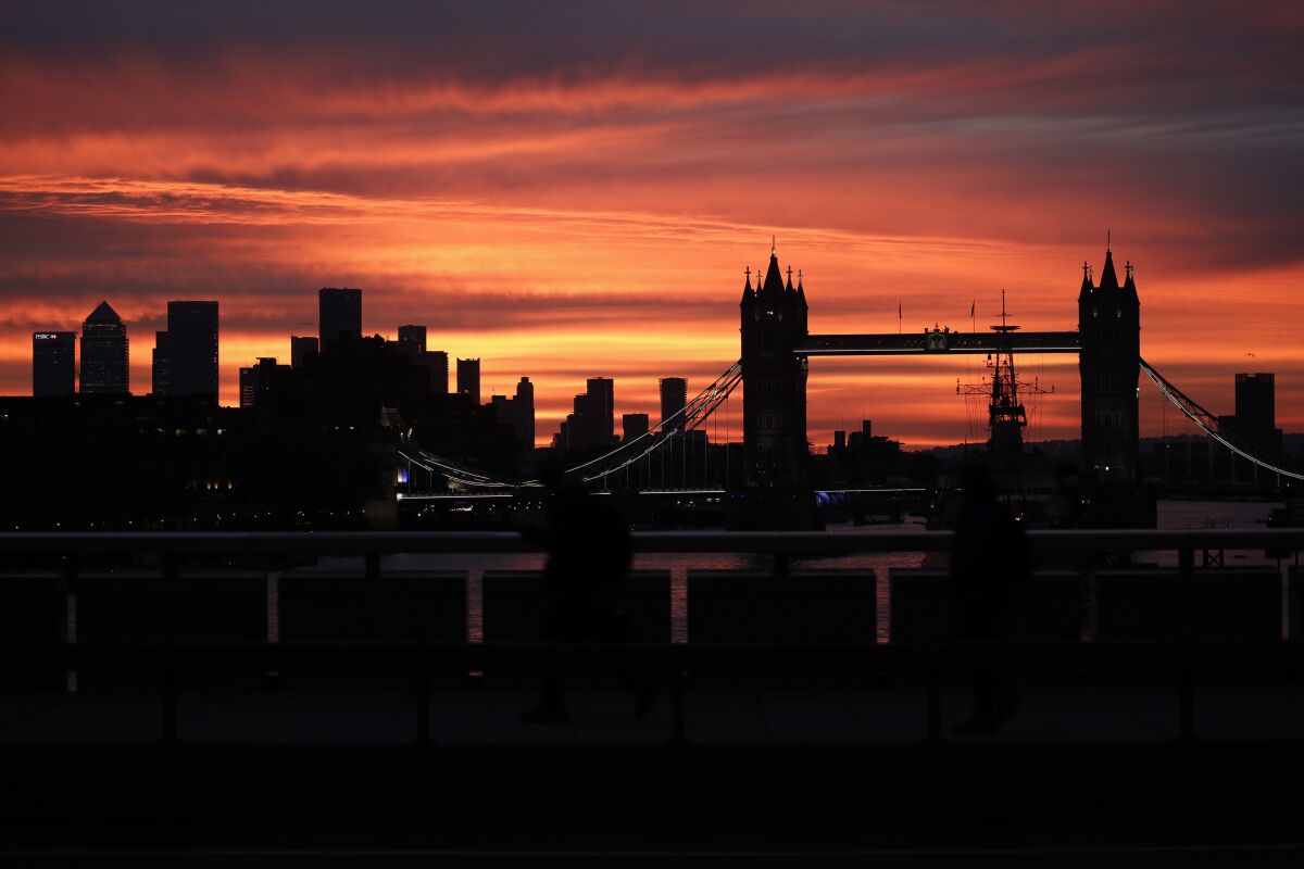 Tower Bridge and the skyscrapers of the Canary Wharf financial district, left, are seen at sunrise in London, Monday, Oct. 12, 2020.(AP Photo/Matt Dunham)