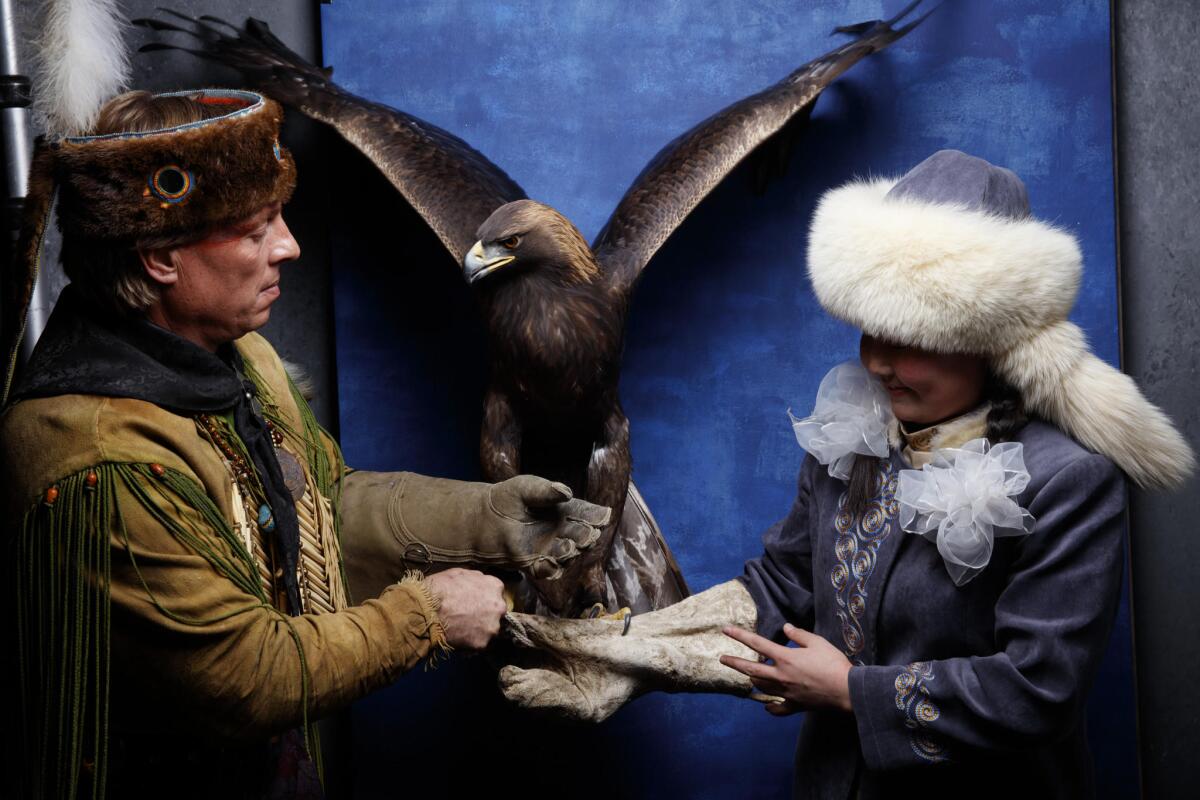 Handler Troy hands off the golden eagle Nuepi to 13-year-old "Eagle Huntress" Aisholpan.