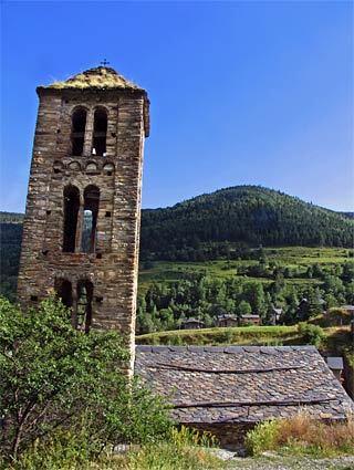 Andorra The campanile of Sant Climent de Pal, one of Andorras many beautiful Romanesque stone churches, towers over the verdant countryside. The tiny landlocked country is nestled in the Catalonian Pyrenees between France and Spain.