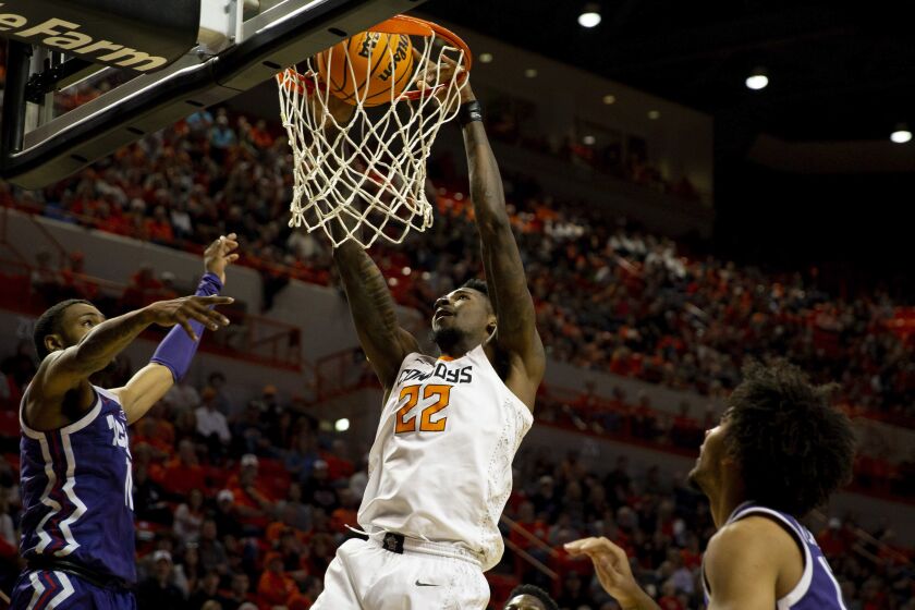 Oklahoma State's Kalib Boone (22) slam dunks the ball in the first half of an NCAA college basketball game against TCU in Stillwater, Okla., Saturday, Feb. 4, 2023. (AP Photo/Mitch Alcala)