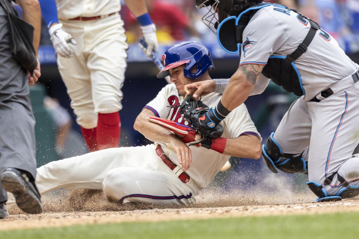 Philadelphia Phillies' J.T. Realmuto is out on attempted steal of home as Miami Marlins catcher Jorge Alfaro (38) makes the tag during the sixth inning of a baseball game Sunday, July 18, 2021, in Philadelphia. (AP Photo/Laurence Kesterson)