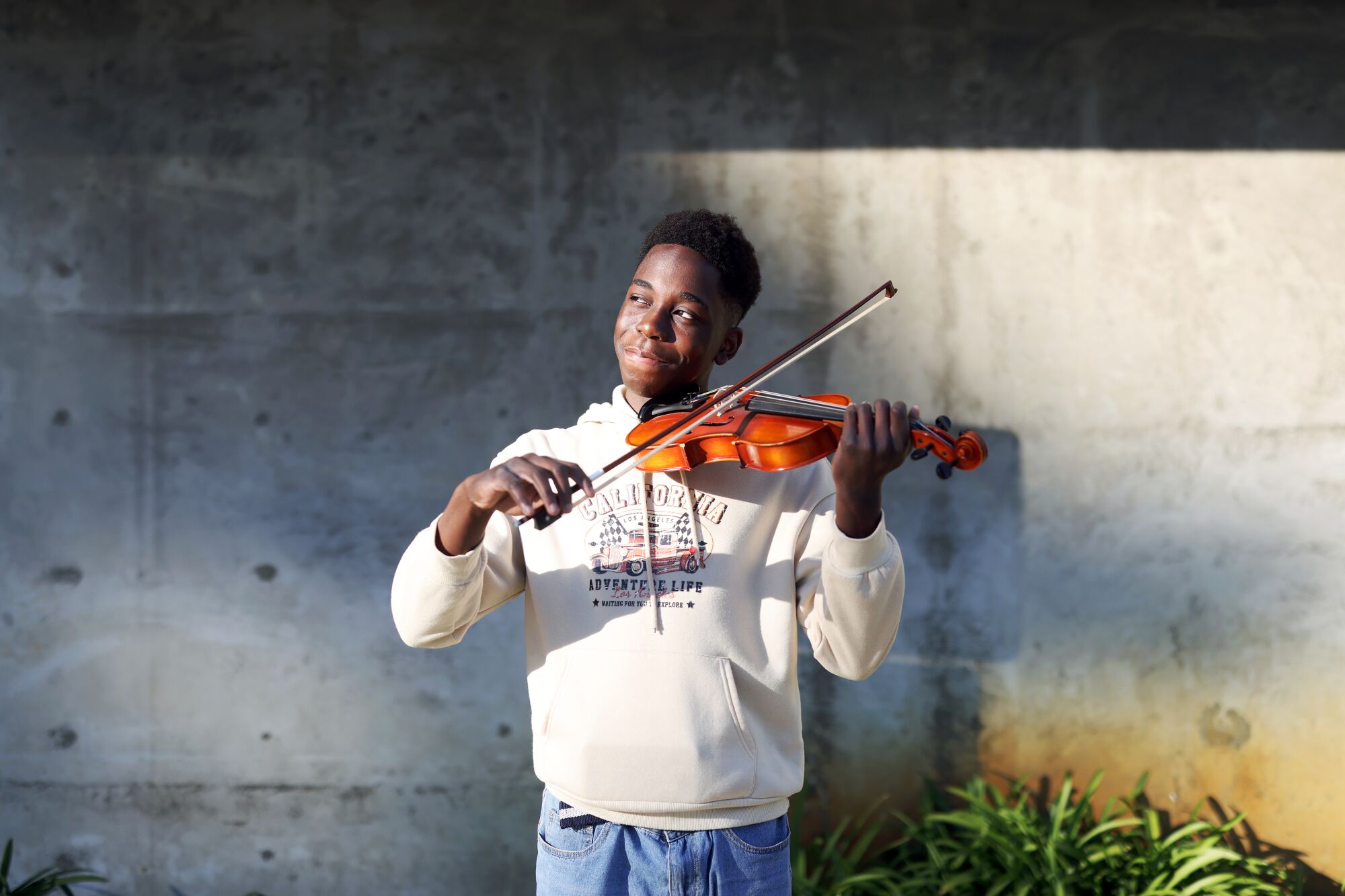 A teenager plays a violin.