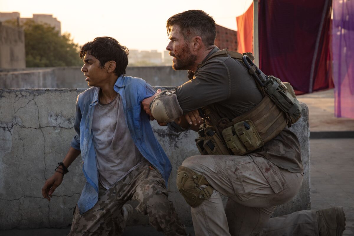 Rudhraksh Jaiswal, left, and Chris Hemsworth in the Netflix action film "Extraction"
