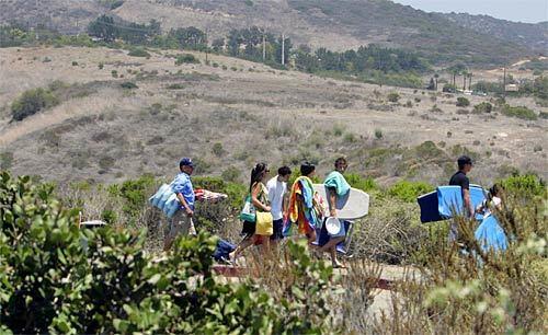 Visitors head for the beach at Crystal Cove State Park. Few visit the parks wilder inland side.
