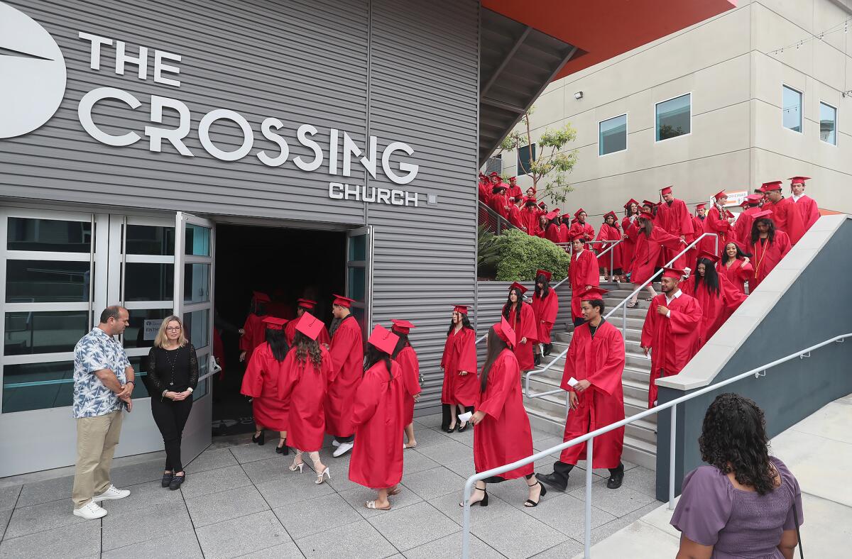 Graduates walk into the Crossing Church during the Back Bay High School commencement ceremony.
