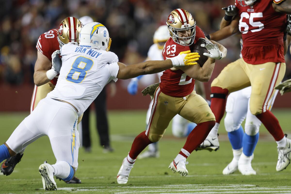 San Francisco 49ers running back Christian McCaffrey carries the ball past Chargers linebacker Kyle Van Noy.