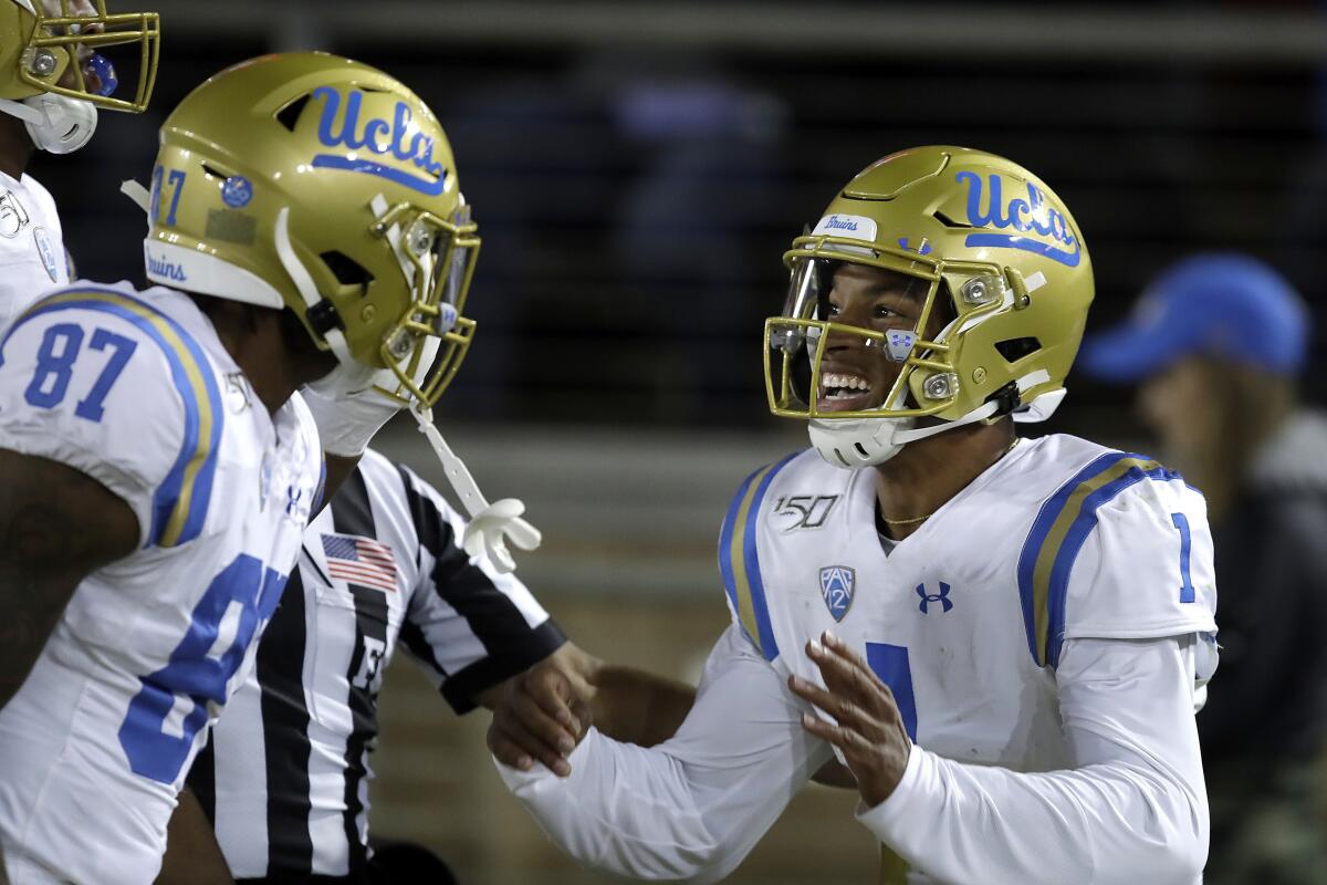 UCLA quarterback Dorian Thompson-Robinson, right, celebrates with Jordan Wilson (87) after scoring a touchdown against Stanford during the first half on Thursday in Palo Alto.