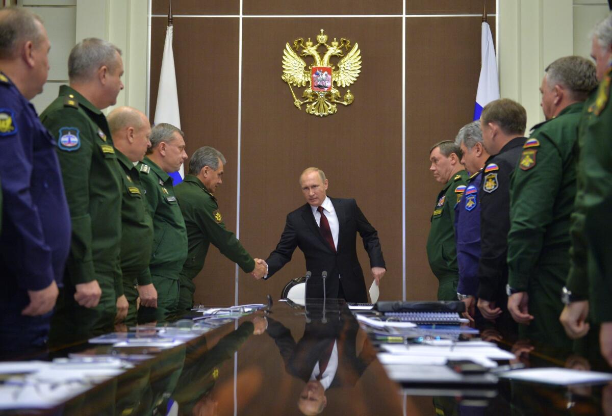 Russian President Vladimir Putin, center, shakes hands with Defense Minister Sergei Shoigu at a meeting with top military officials in Sochi, Russia, on Nov. 24.