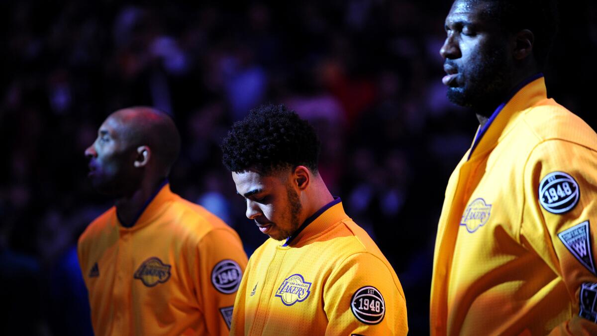 Lakers rookie D'Angelo Russell, center, listens to the national anthem between Kobe Bryant and Roy Hibbert before their game Wednesday night at the Staples Center.