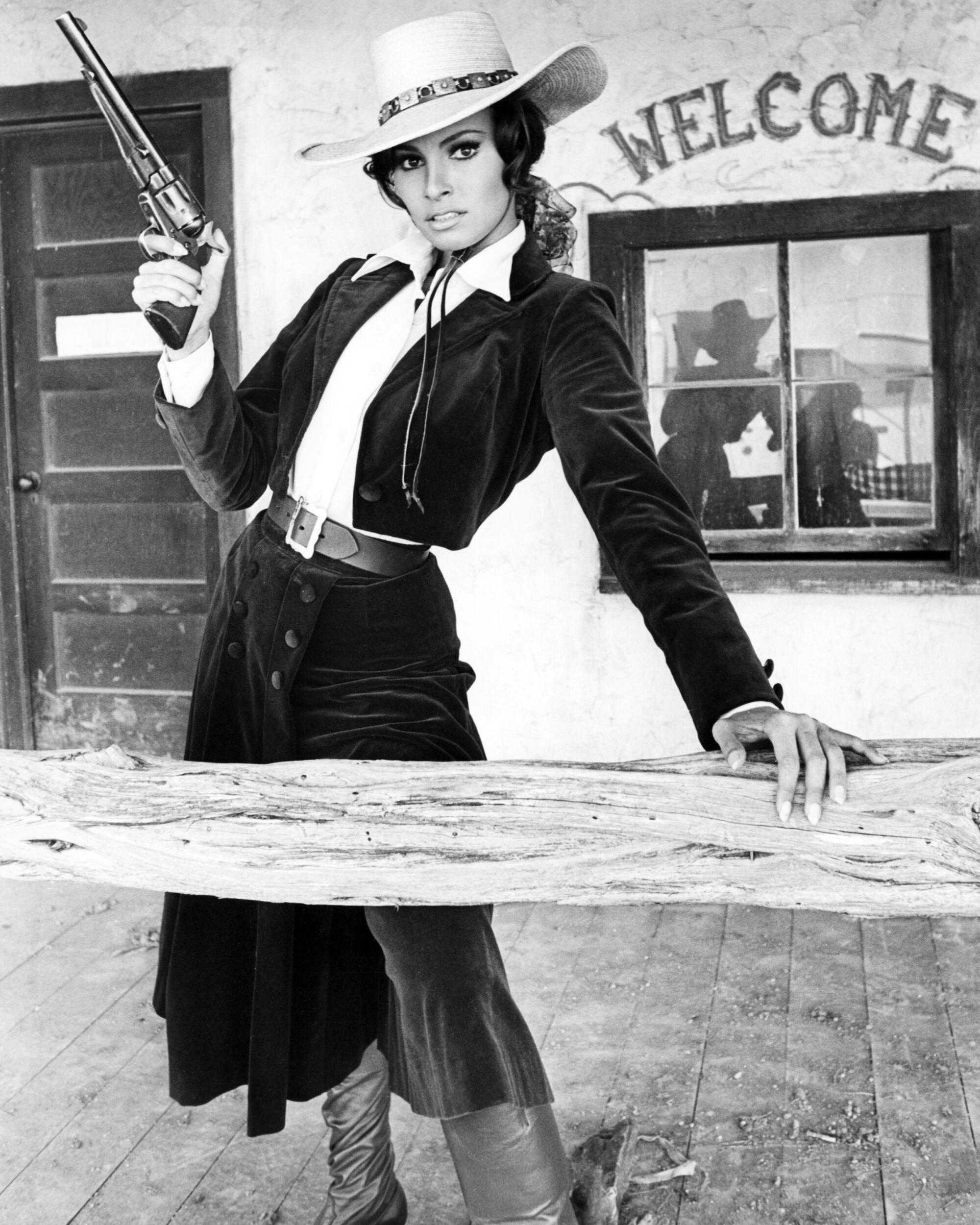 actor Raquel Welch brandishing a prop gun