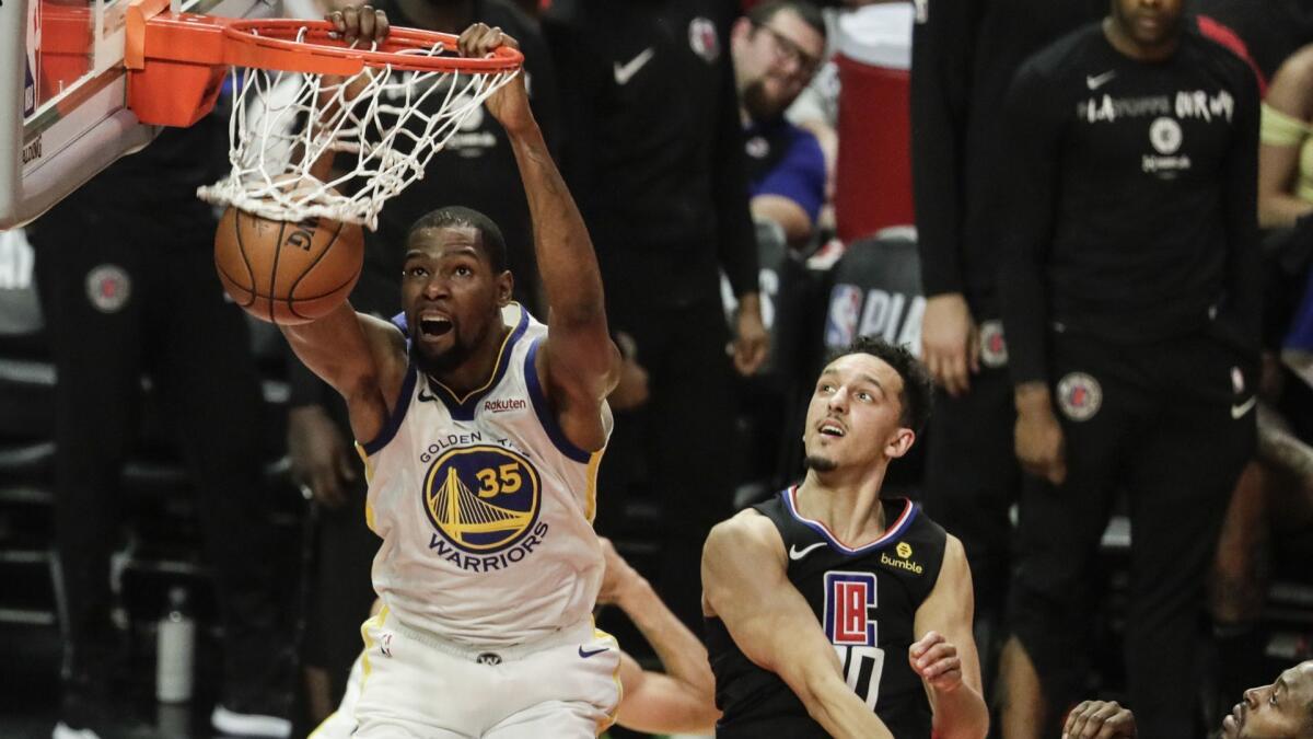 Golden State Warriors forward Kevin Durant slams home two points late in the fourth quarter over Clippers guard Landry Shamet in Game 4 of the first round of the NBA Western Conference playoffs at Staples Center on April 21.