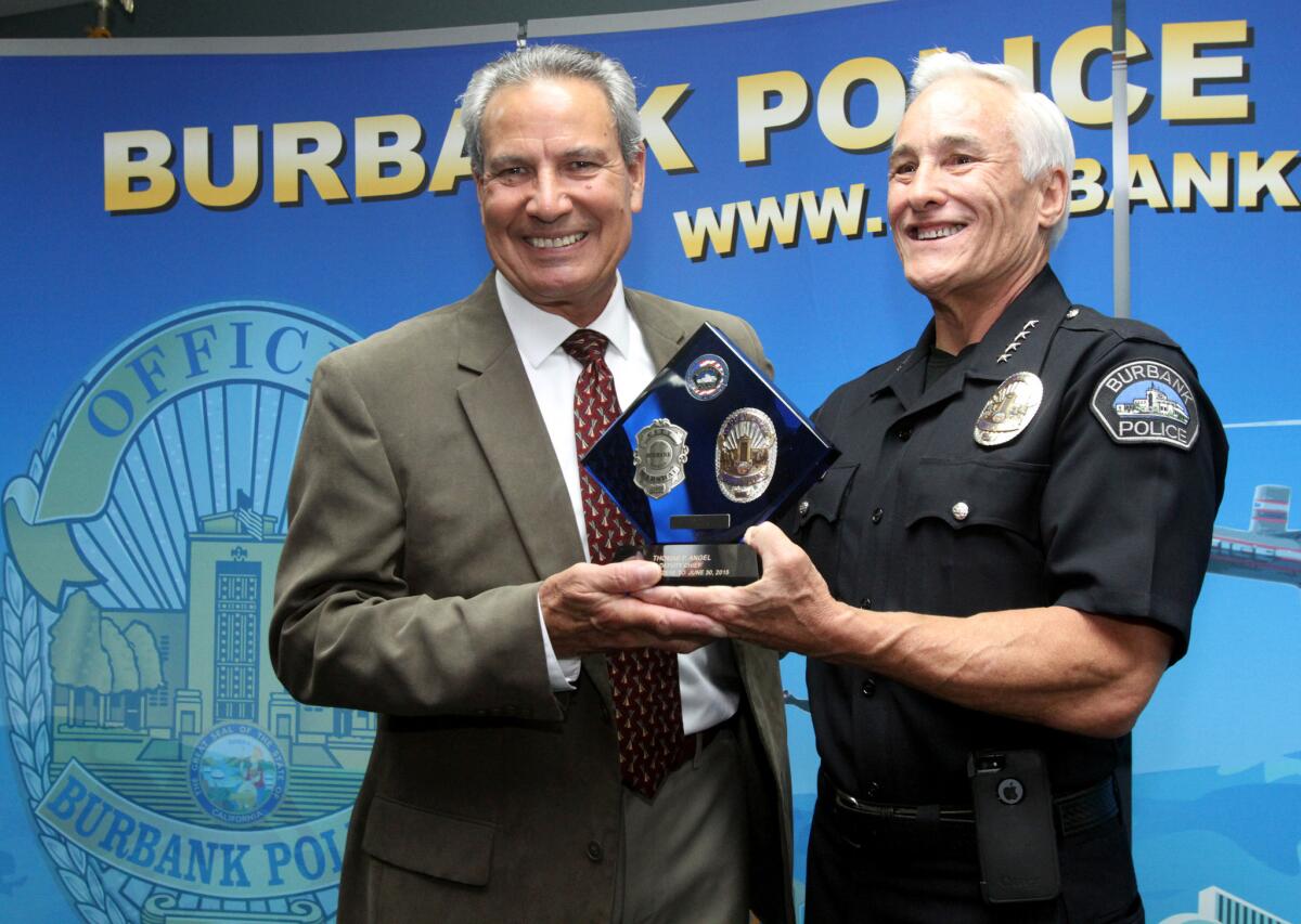 Burbank Police Dept. Deputy Chief Tom Angel, left, is given a plaque by Chief Scott LaChasse during brief retirement ceremony at police headquarters in Burbank on Tuesday, June 23, 2015.