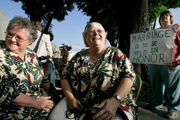 Elaine Martin, 61, left, and Cindy Gise, 59, wait to get married at the Los Angeles County Clerk's office in Norwalk while Karen Wilson protests same-sex marriages. Martin and Gise have been together for 40 years.