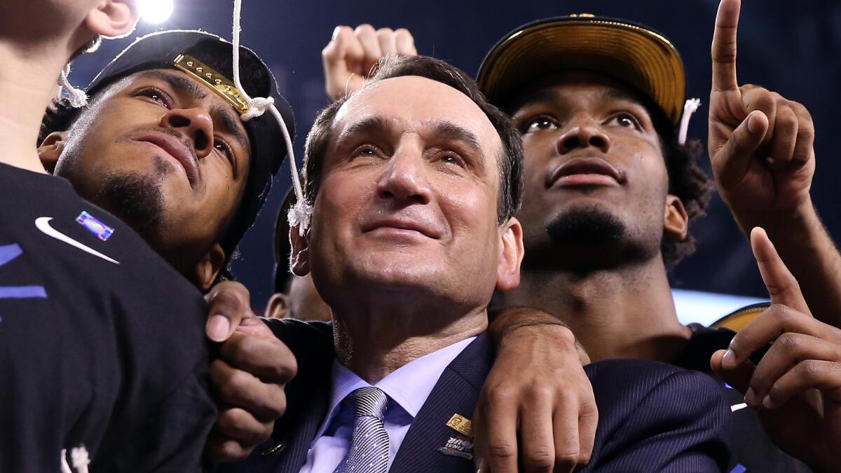 Duke Coach Mike Krzyzewski celebrates with his players after the team's NCAA championship victory over Wisconsin on Monday.