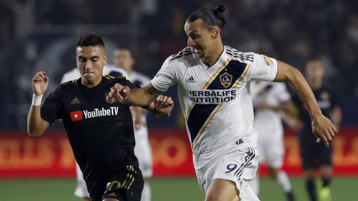 LAFC midfielder Eduard Atuesta, left, battles for control of the ball against Galaxy forward Zlatan Ibrahimovic during an August 2018 match.