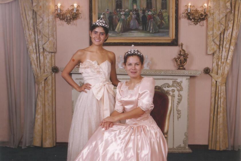 A formal portrait of artists Gina Arizpe and Marcela Quiroga poses for a faux quinceañera portrait in frilly pink gowns