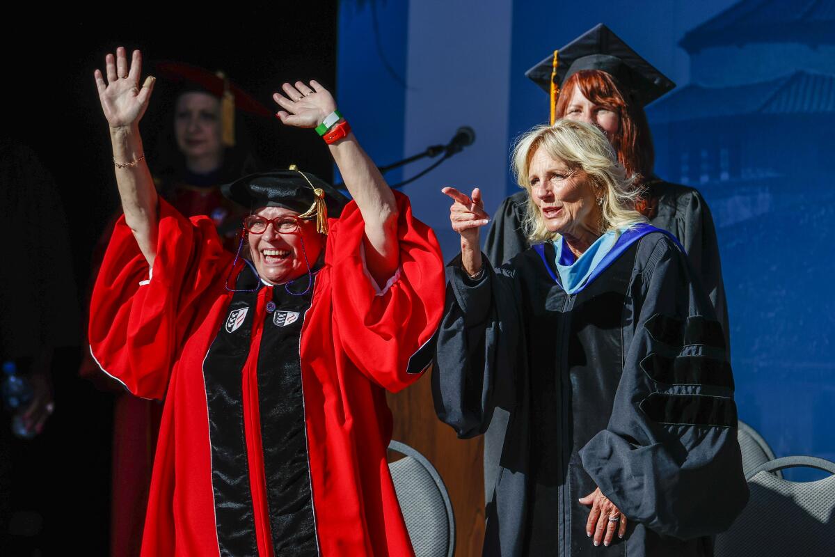 First Lady Jill Biden, right, and Los Angeles City College President Mary Gallagher wave to graduates.